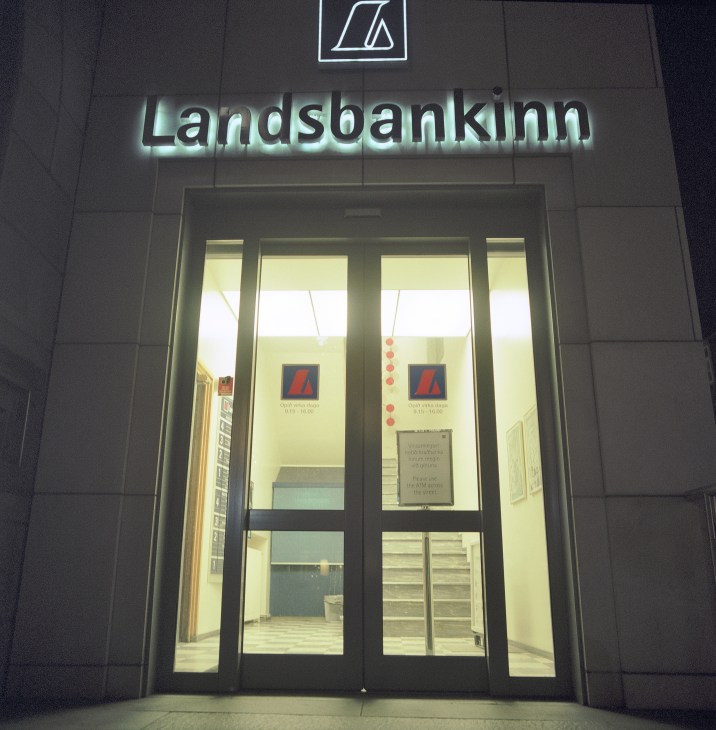 Landsbankinn bank headquarters building entrance illuminated at night in Reykjavik.
