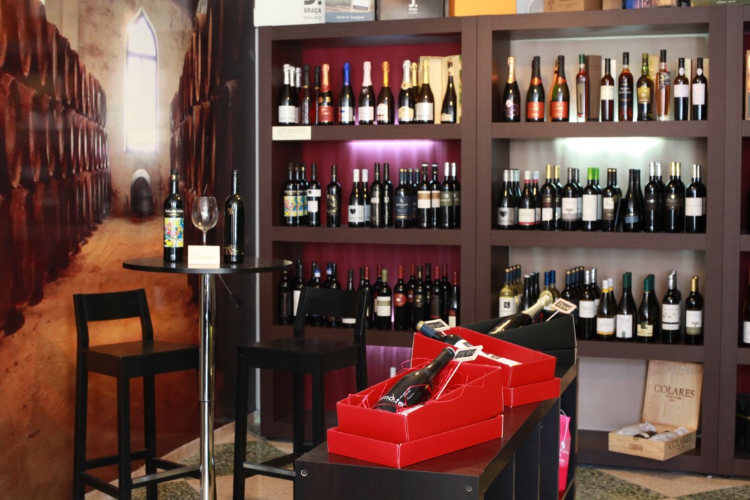 Portuguese wines displayed on illuminated shelves at DegustArte wine shop in Lisbon.