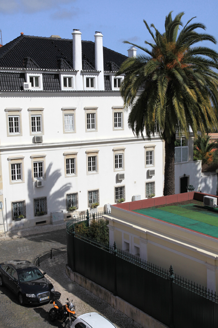 White neoclassical building with palm tree and courtyard in Lapa, Lisbon