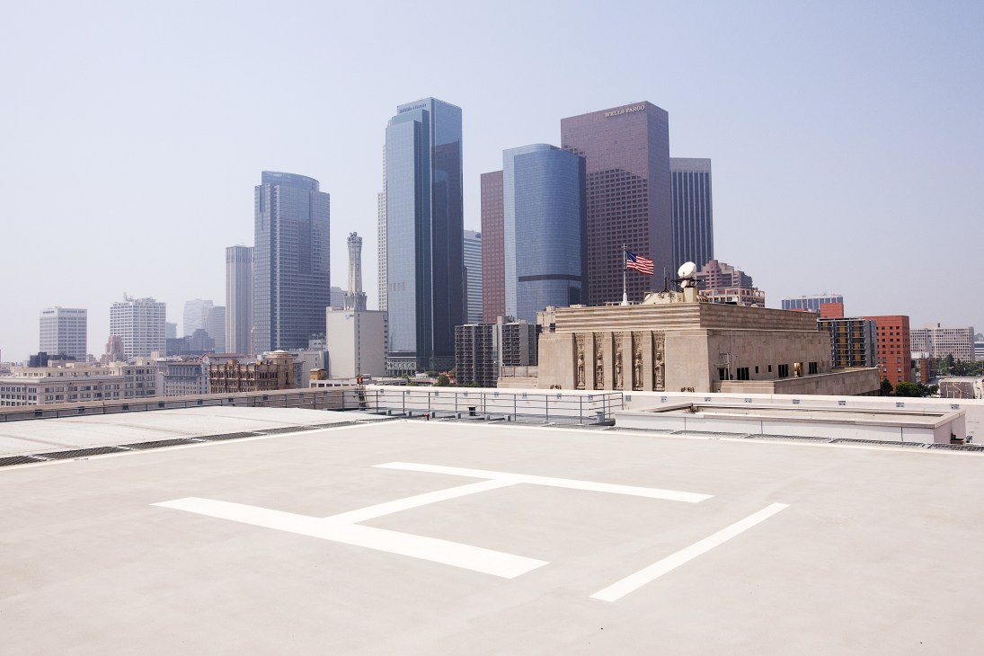 Helicopter pad on rooftop of LAPD headquarters with downtown Los Angeles skyline in background.