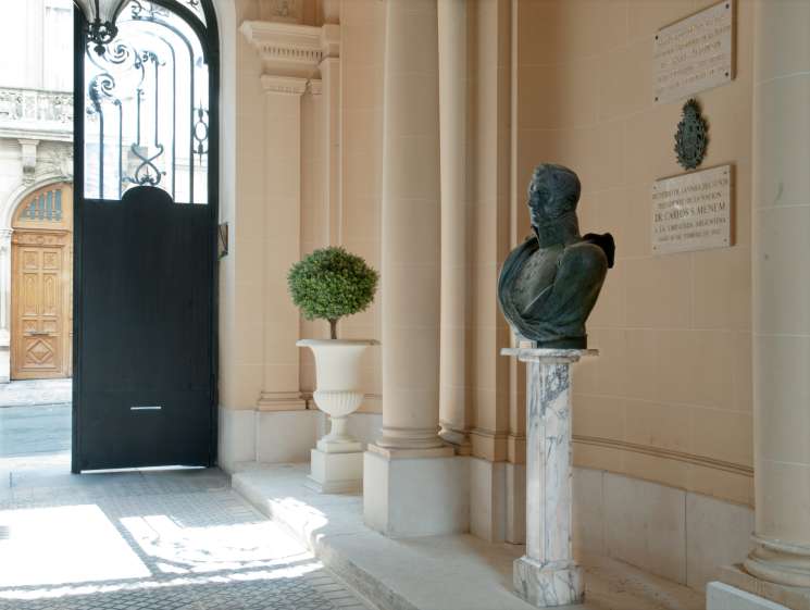 Interior of the Argentine Embassy in Paris showing a classical bust sculpture, ornate columns, and a potted topiary plant.