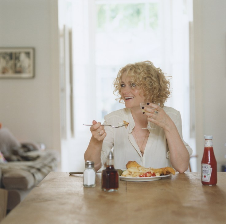 Alison Goldfrapp eating fish and chips at a wooden table in her east London home.