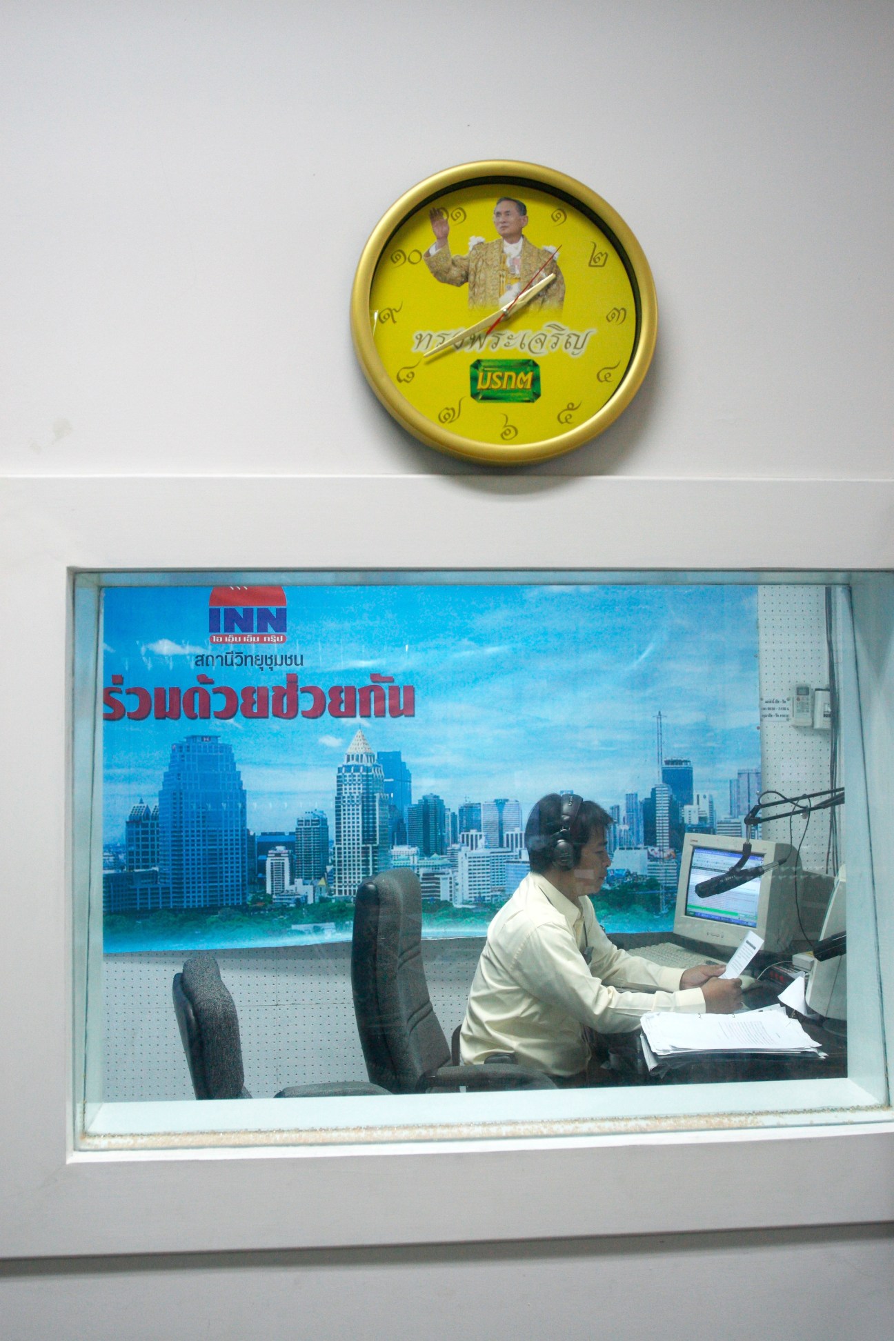 Radio DJ at RDCK station in Bangkok broadcasting live on air at microphone.