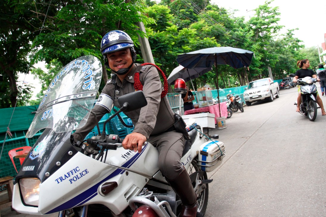 Traffic policeman Sgt Pichet Wisetchoke on a white and blue motorcycle in Bangkok.