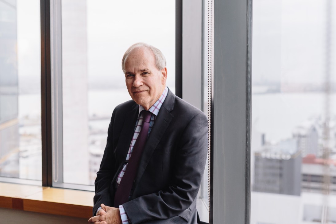 Mayor of Auckland Len Brown posing by a window with city skyline view
