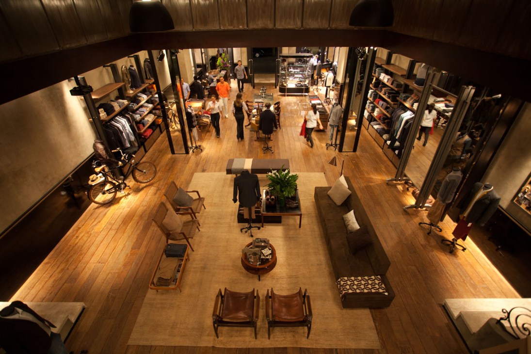 Interior of Noir, Le Lis boutique with wooden flooring, clothing displays, and seating areas designed for customer comfort.