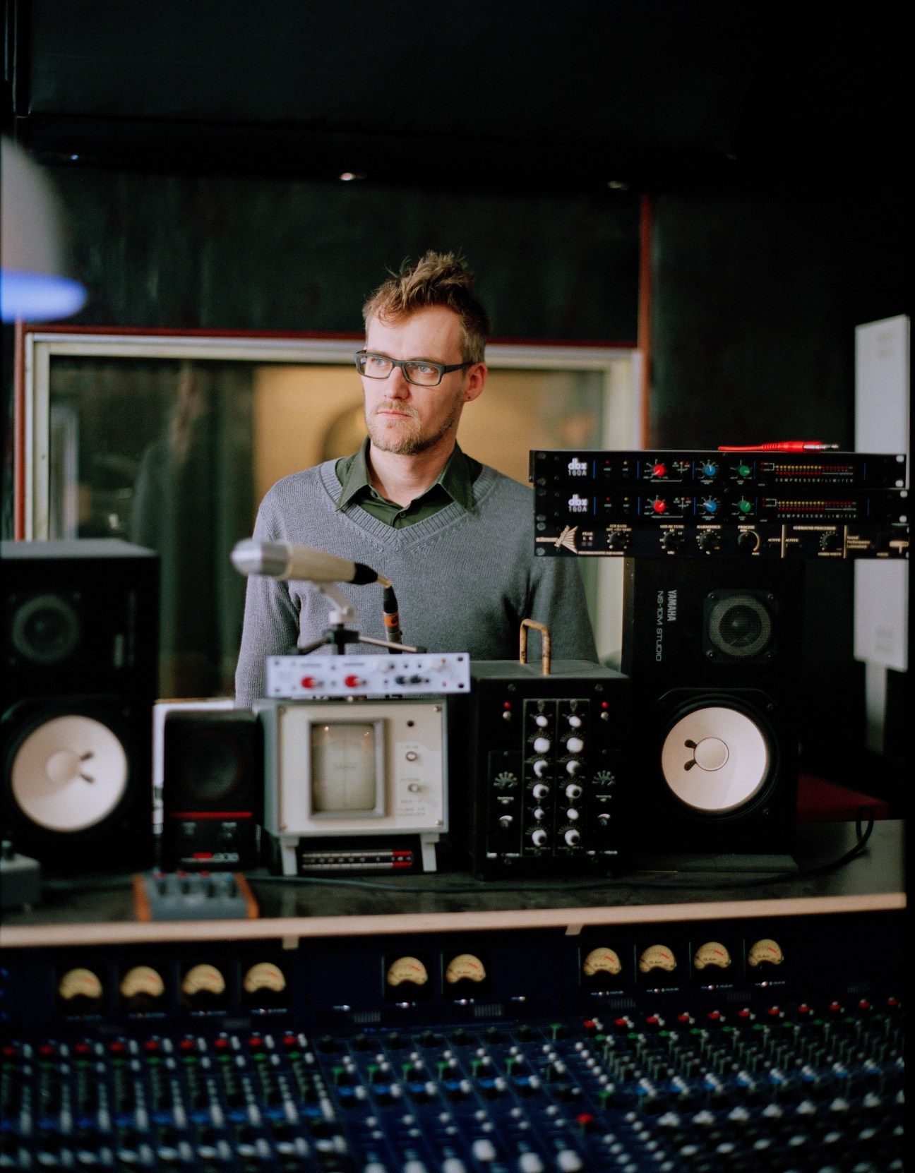 Patrick Pulsinger stands at his recording studio surrounded by electronic music production equipment and synthesizers.