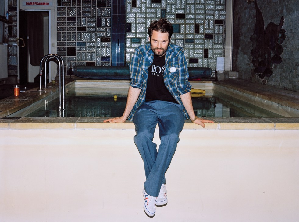 Hennes Weiss, co-owner of the Pratersauna, sits on a bath ledge in the converted 1950s sauna venue.