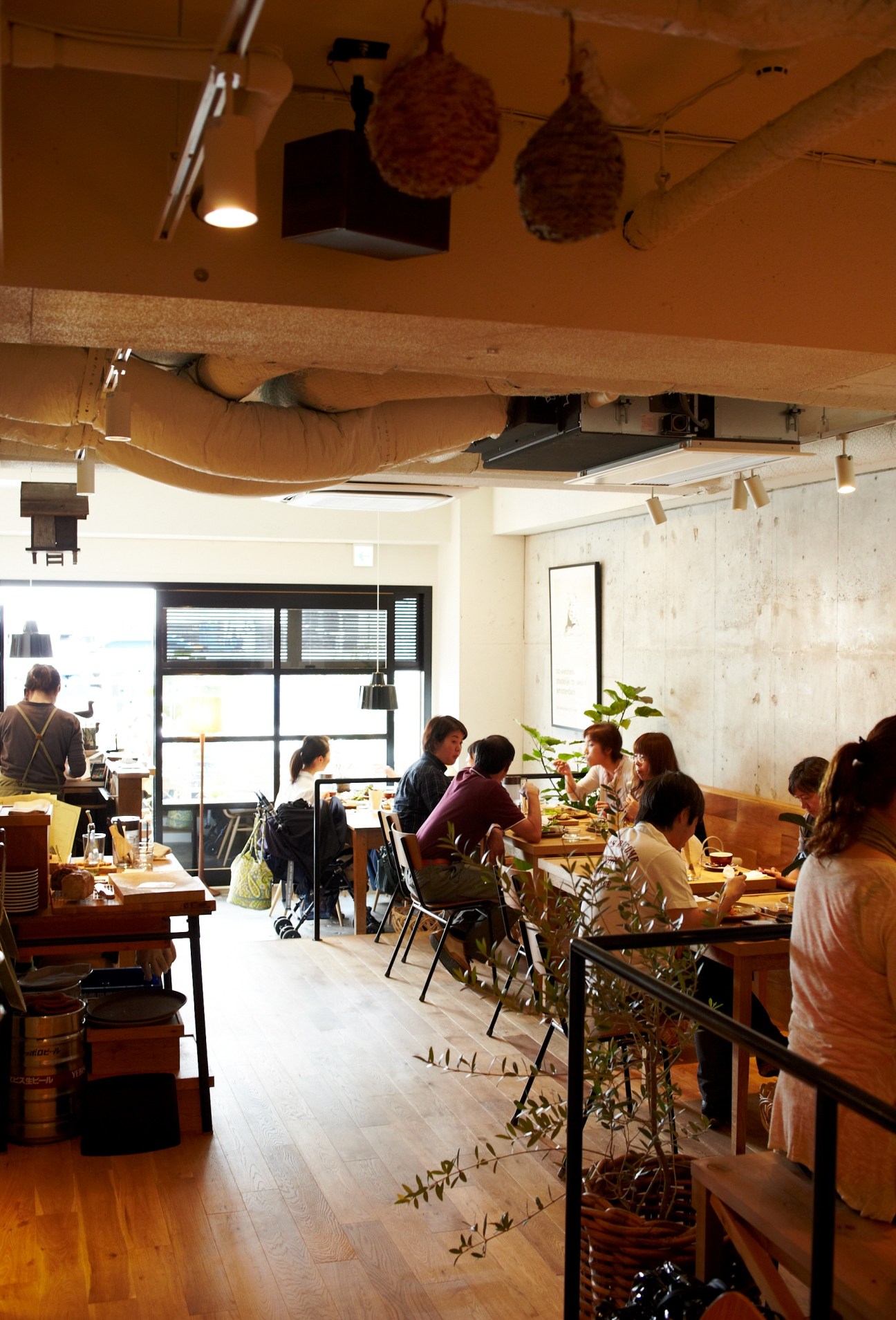 Interior of Life Son restaurant in Tokyo with diners seated at wooden tables and warm lighting.