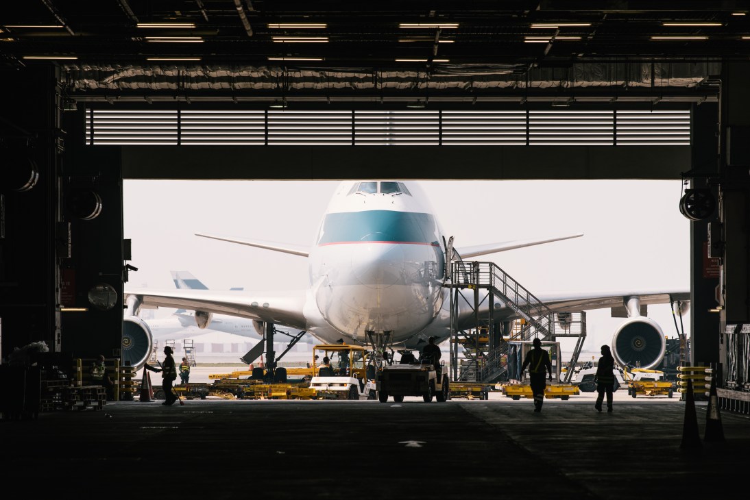 Boeing 747-8 freighter aircraft being loaded with cargo inside a hangar at Hong Kong International Airport.
