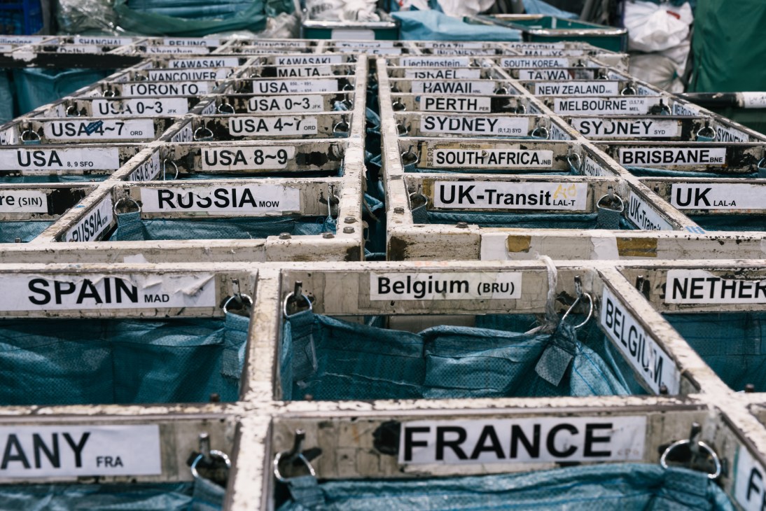 Mailbags organized by destination country in sorting bins at Hong Kong's Air Mail Centre.