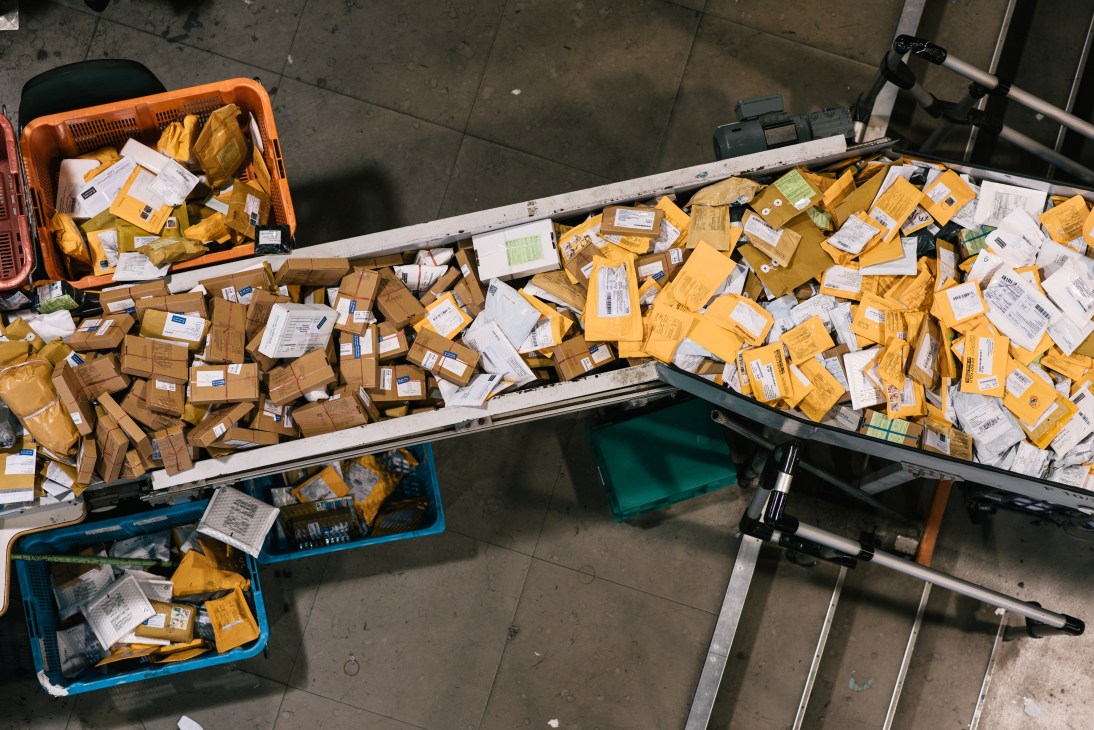 Yellow and brown airmail packets sorted in cargo handling system at Hong Kong airport.