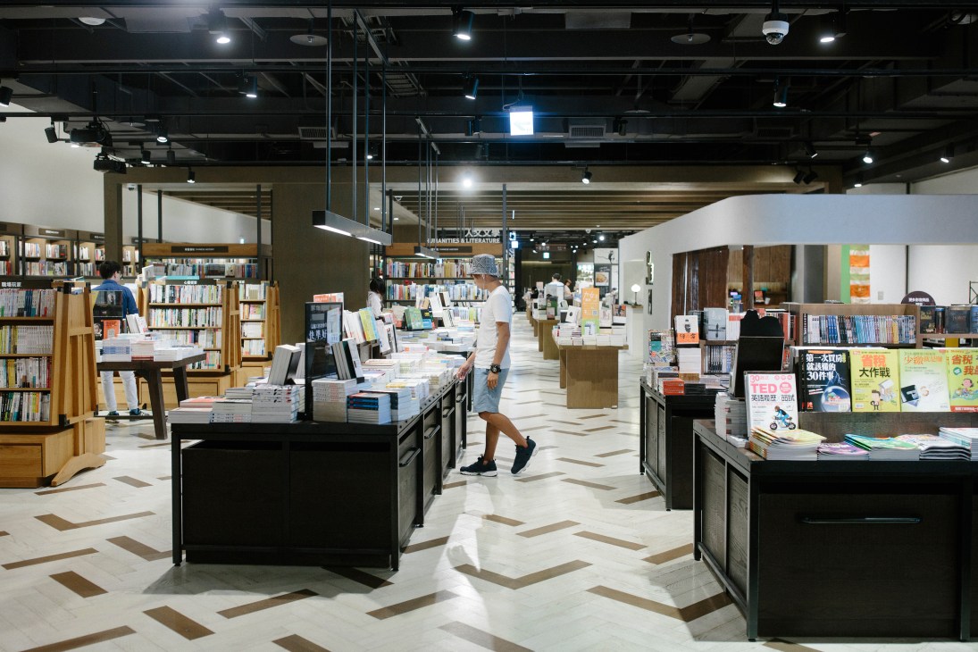 Top floor of Eslite Spectrum bookstore with shelves, display tables and customers browsing.