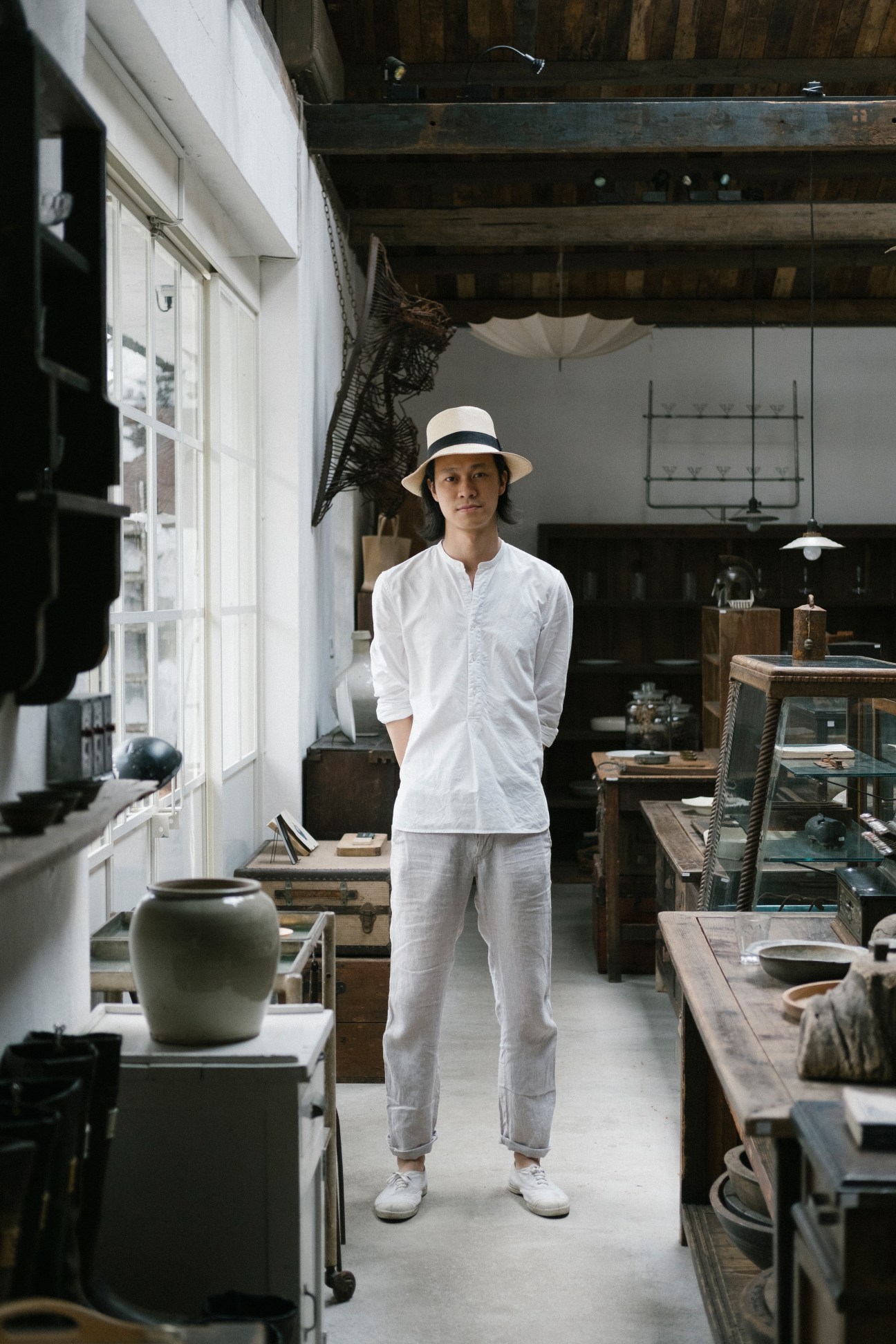 Jin Chen, founder of Antique Delicate furniture shop, stands in his warehouse surrounded by antique pieces and design items.
