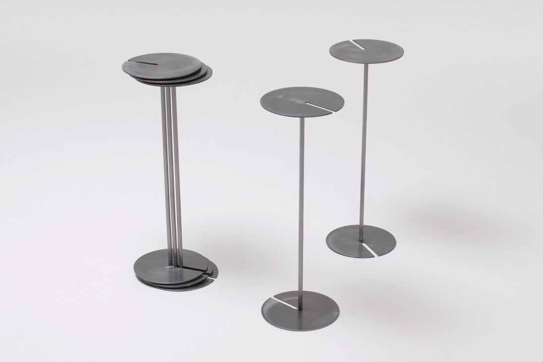 Three tall metal stands with circular tops and bases by designer Yota Yakuda.