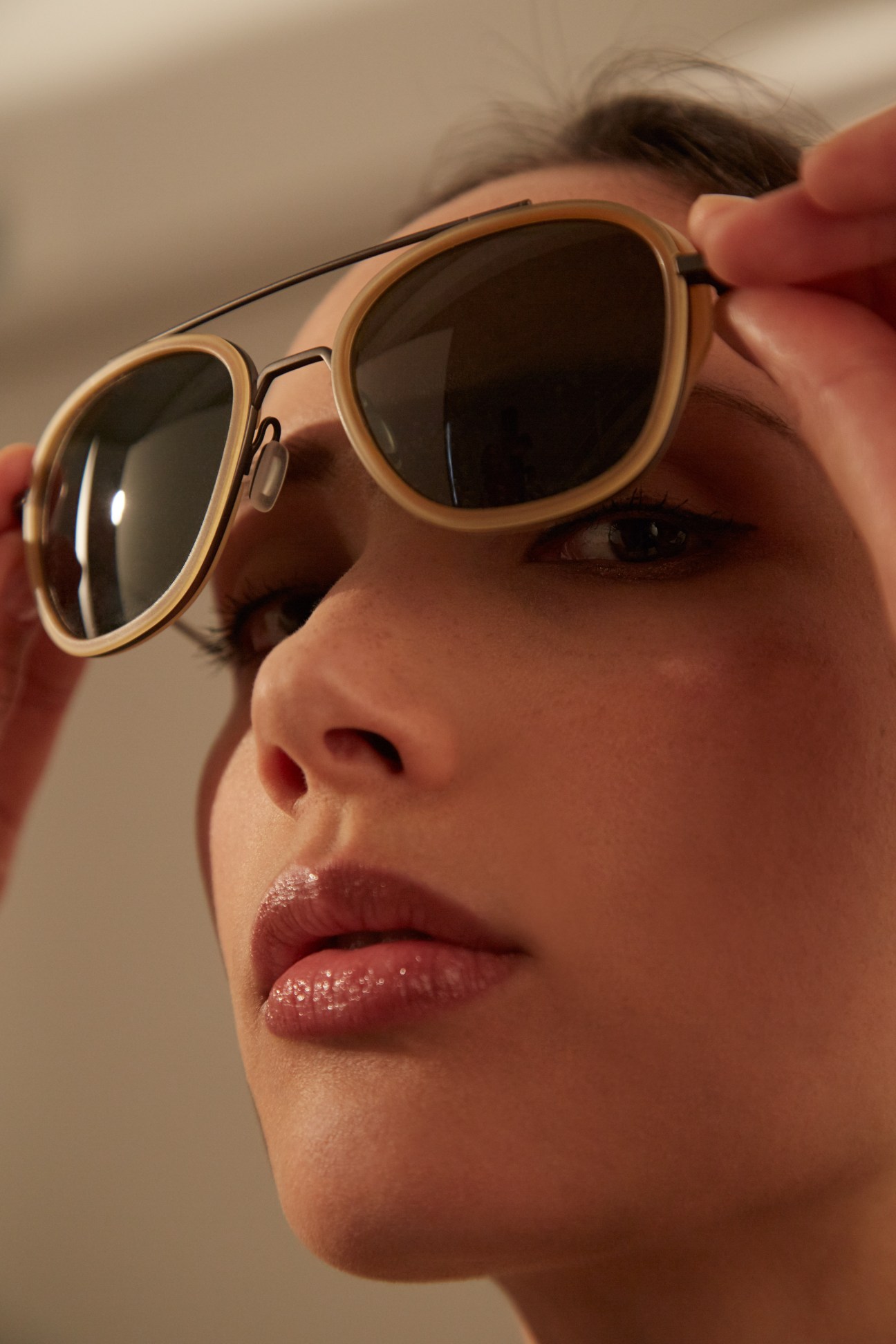 Person wearing tan-framed Vuarnet sunglasses with dark lenses