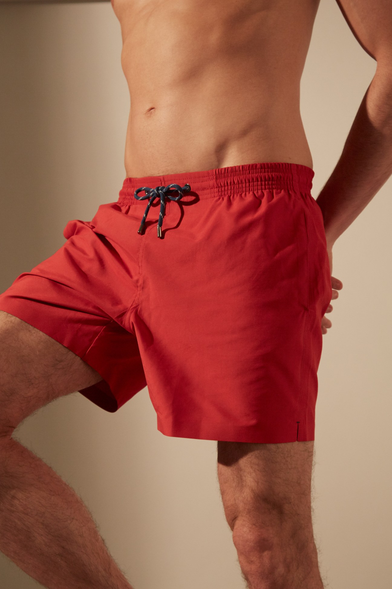 Man wearing red swim shorts with black drawstring by Marané