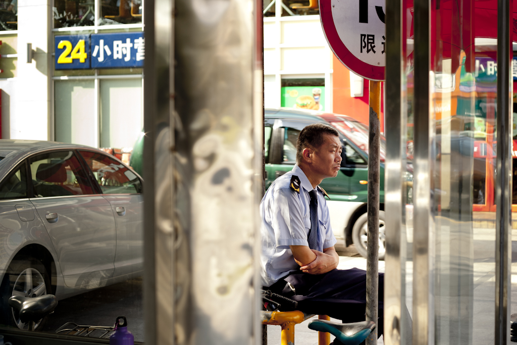 A uniformed security guard sits in a car park booth in Dongguan, China.