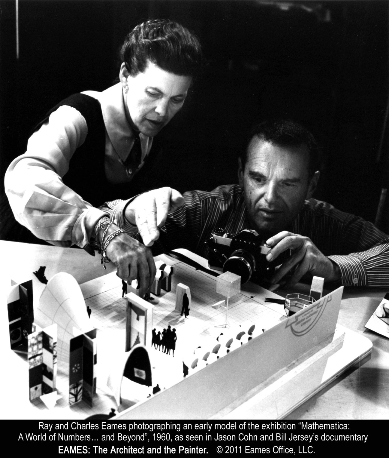 Ray and Charles Eames photographing a model of the 1960 'Mathematica' exhibition.