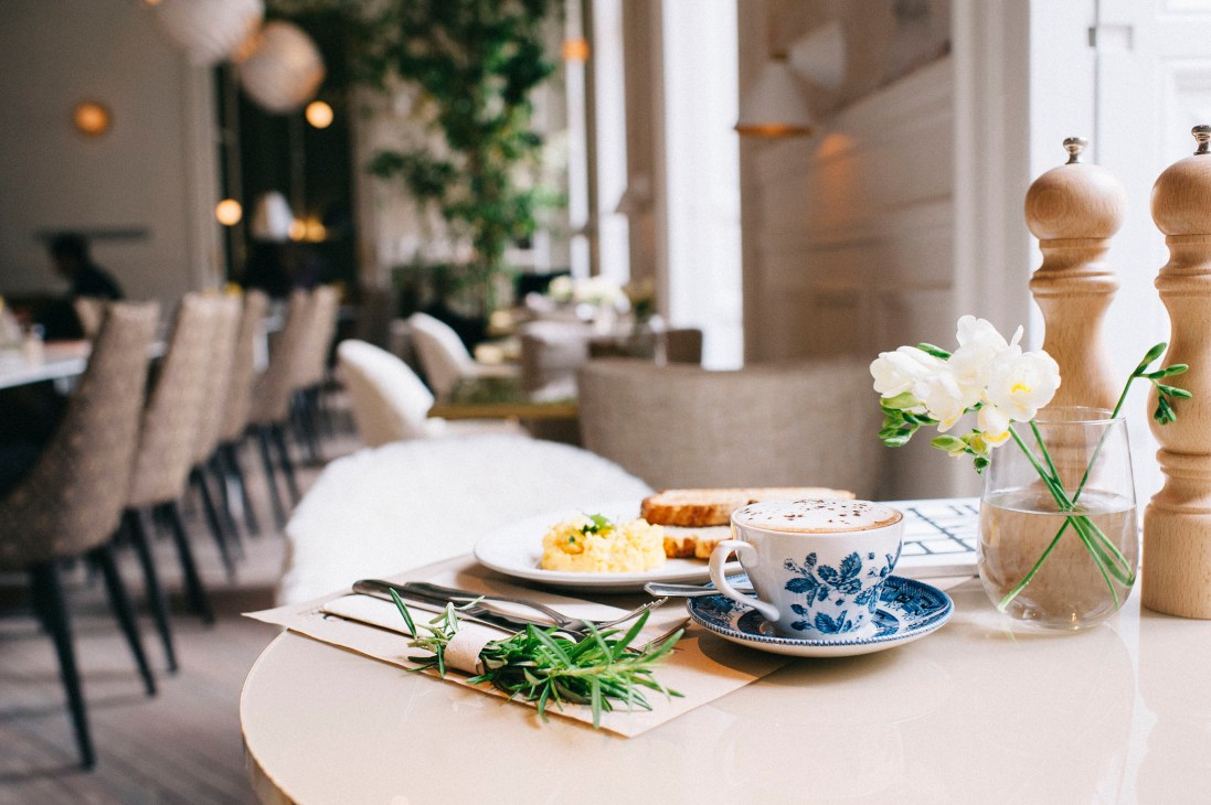 El Imparcial restaurant table setting with coffee, pastries and white flowers in Madrid