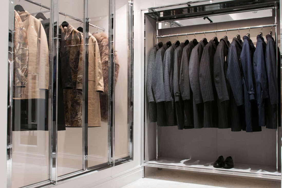 Mackintosh store window display with waterproof coats and tailored jackets on chrome rails.