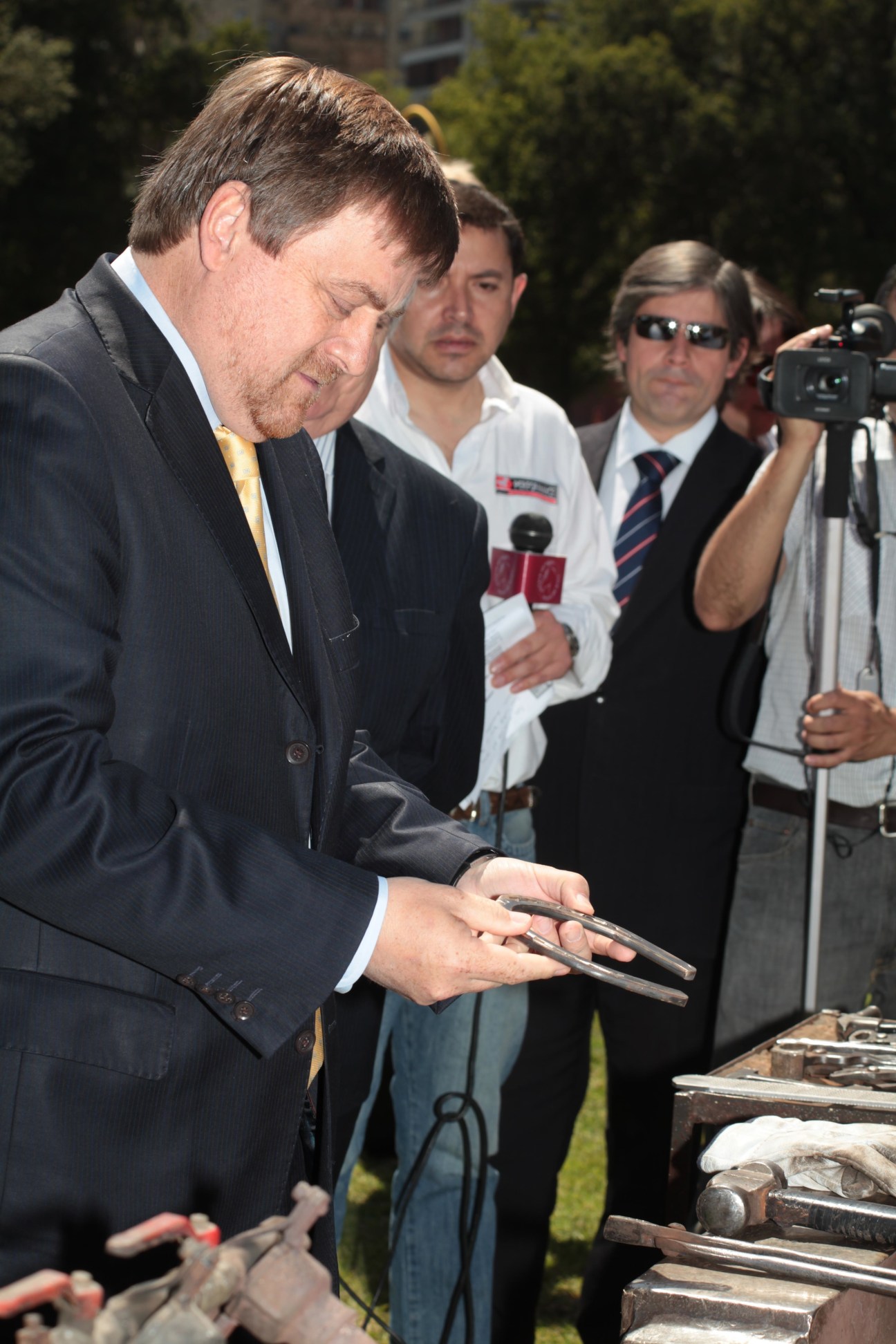 Chilean mining minister Hernán de Solminihac examines a copper comb at a public event.
