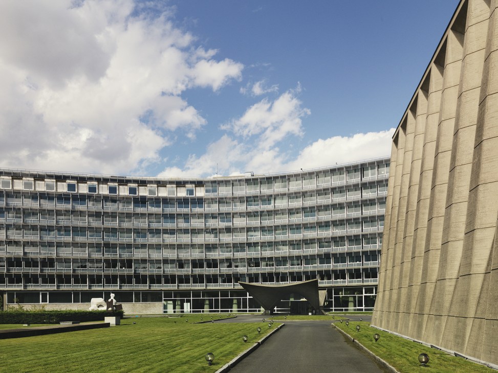 Modernist Y-shaped Unesco headquarters building in Paris with curved concrete facade and manicured forecourt.