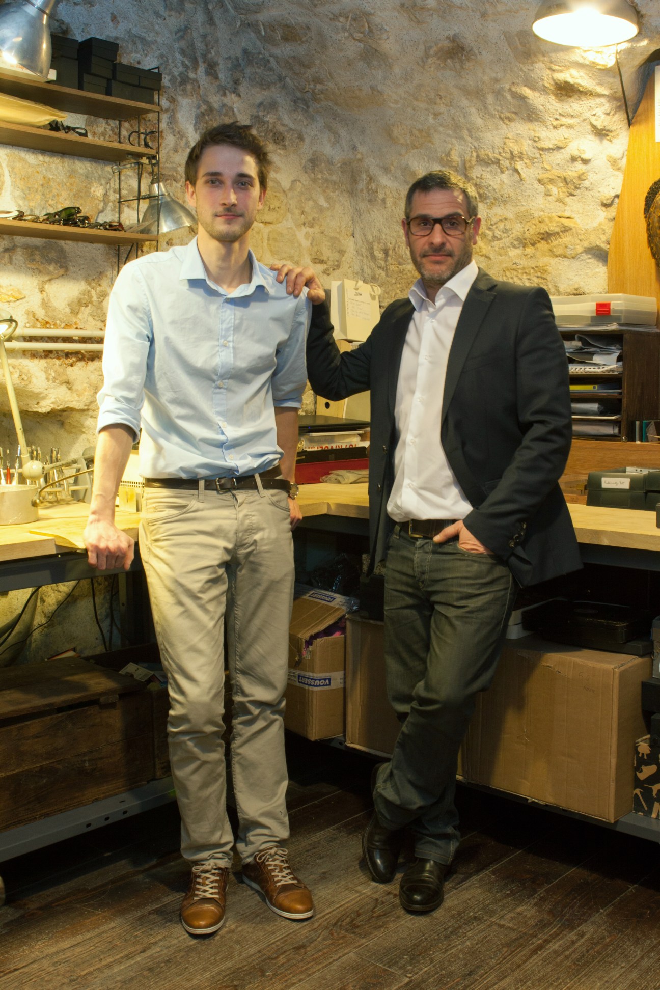 Arnaud Falce and Franck Bonnet stand together in their basement atelier at Maison Bonnet eyewear firm.
