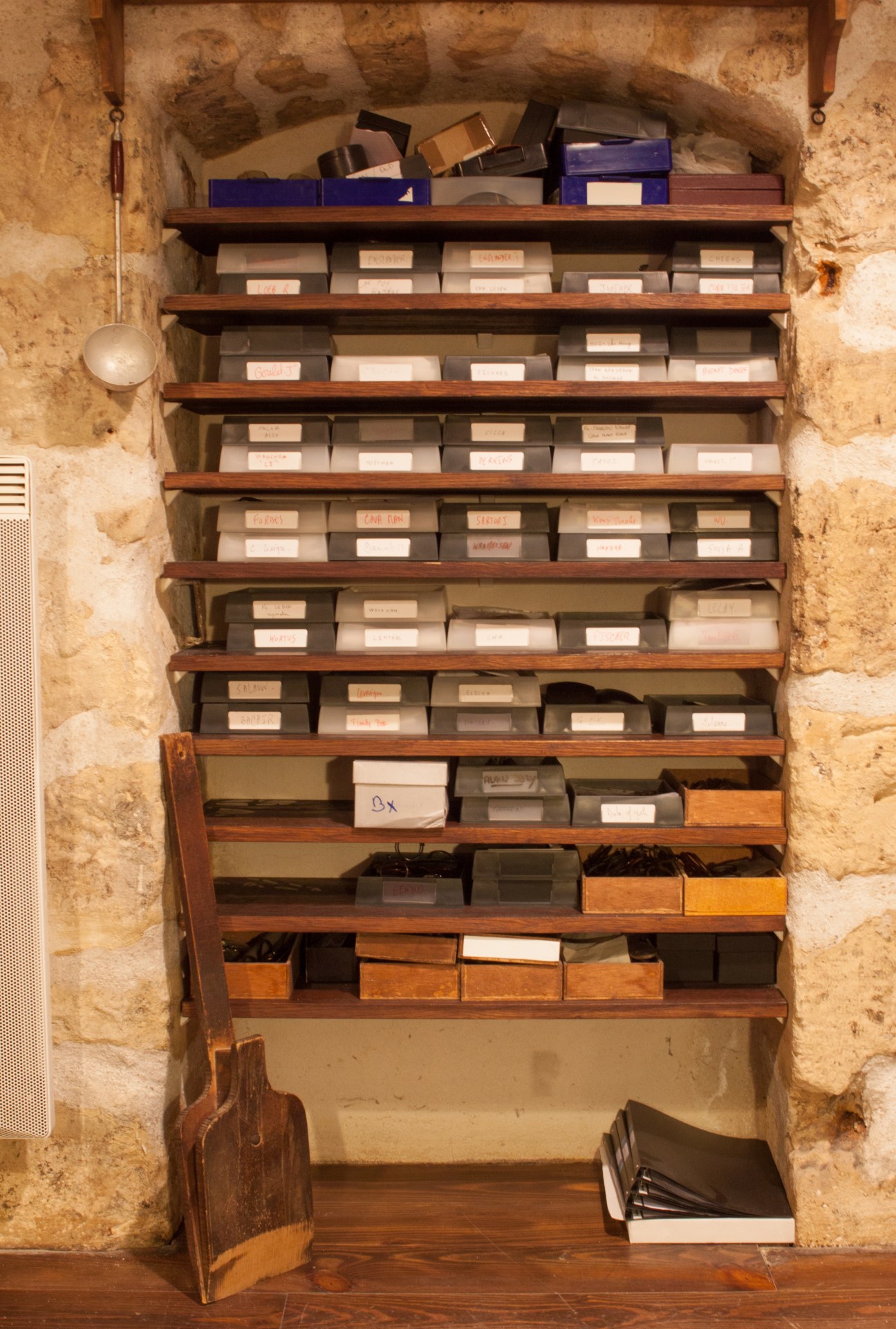 Wooden shelves with neatly organized boxes of eyeglass frames in the Maison Bonnet atelier.