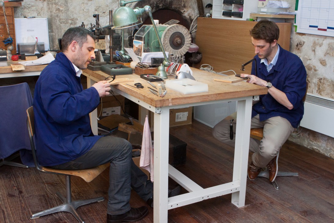 Franck Bonnet and apprentice Arnaud Falce work together at a wooden table in the Maison Bonnet atelier.