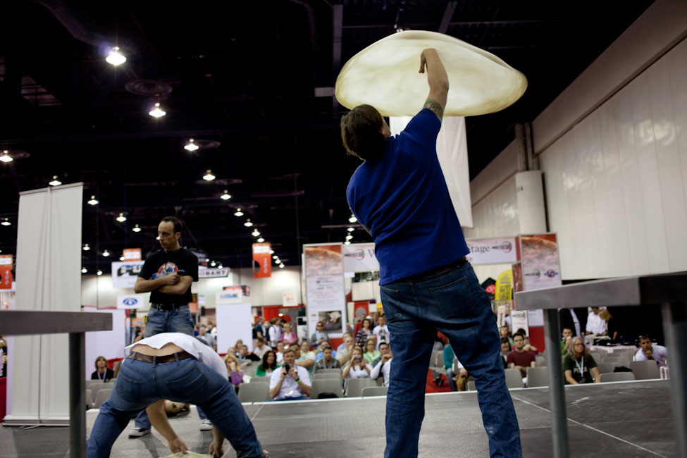 Pizza makers demonstrate dough stretching at the World Pizza Games competition at the International Pizza Expo.