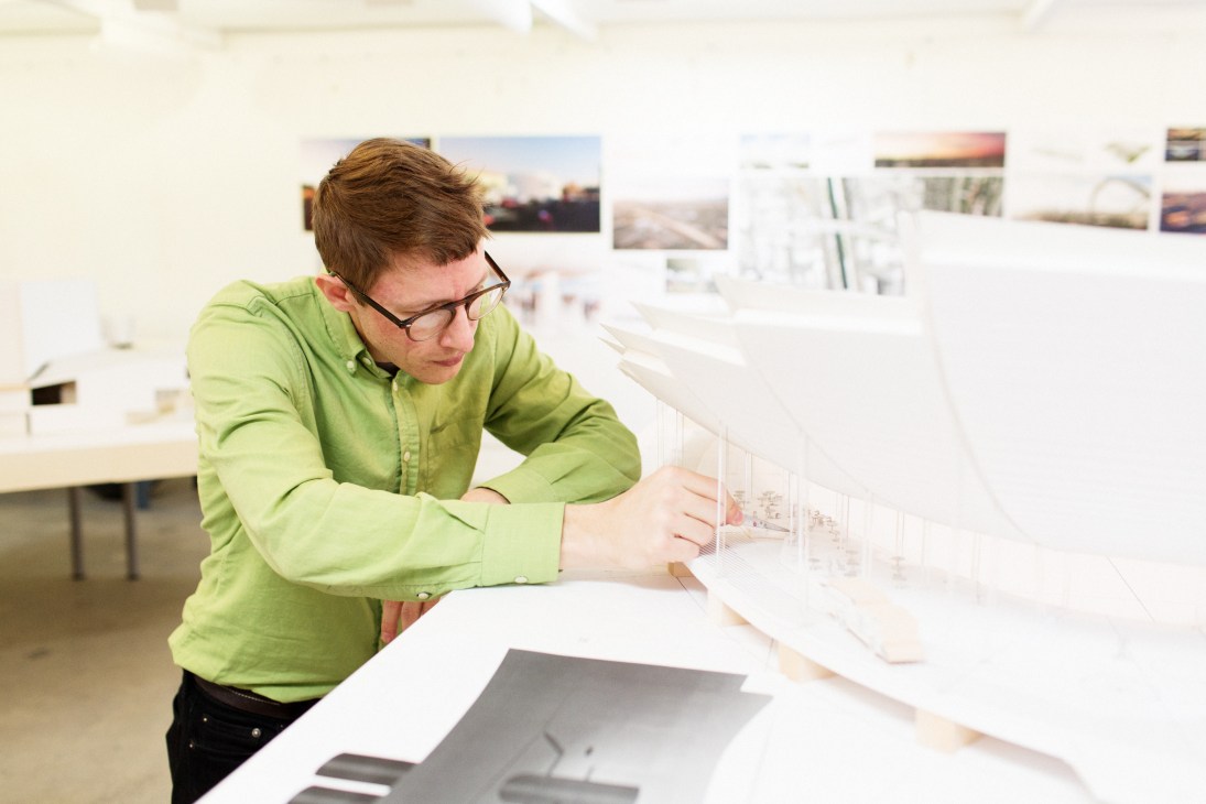 Architect Michael Maltzan examines architectural models at his design desk in his Silver Lake office.