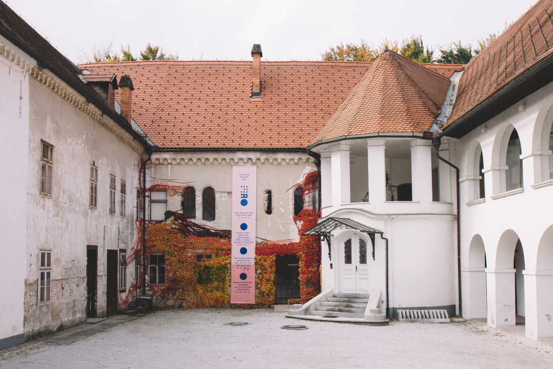 Fuzine Castle courtyard with ivy-covered walls and classical white columns housing MAO shop.