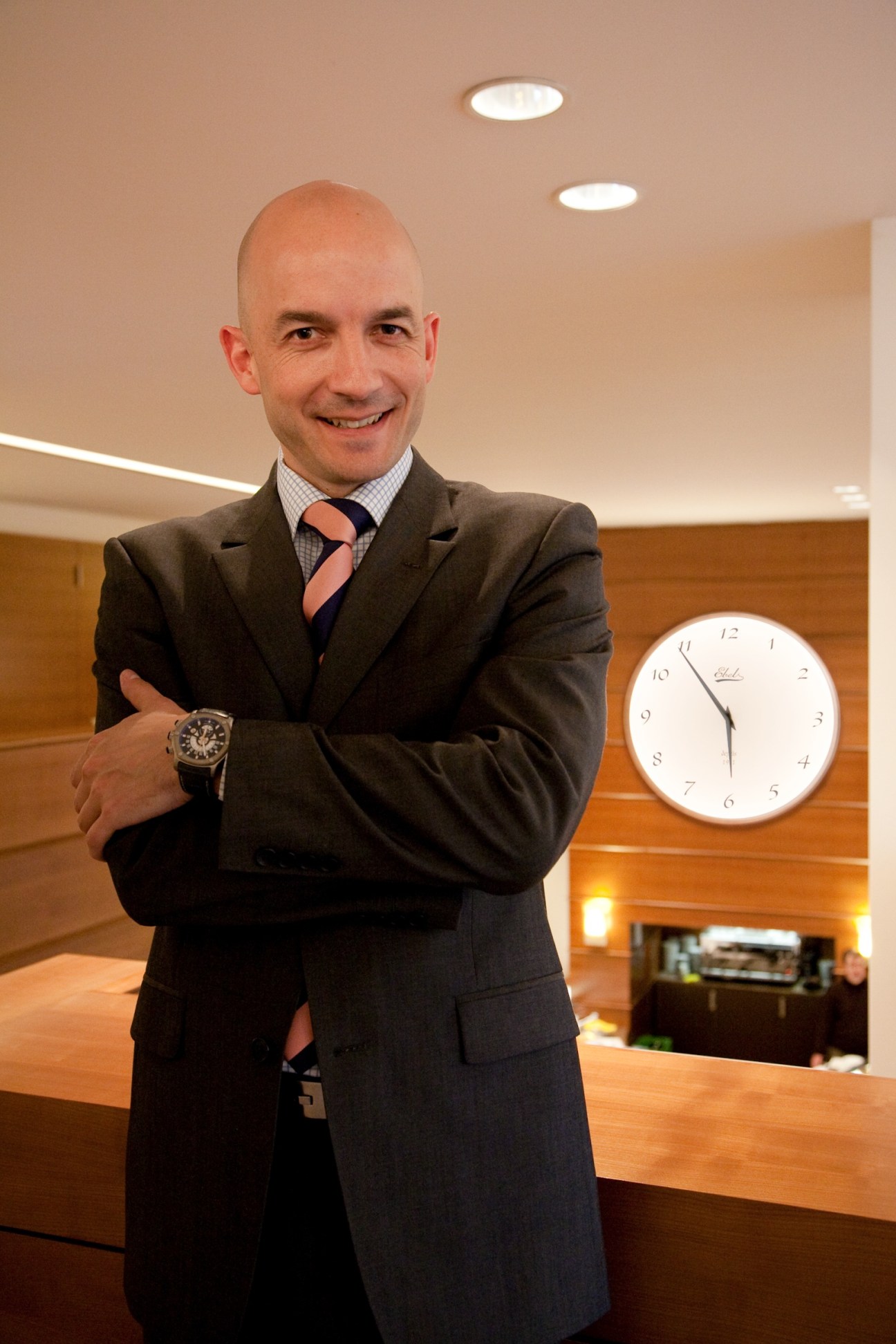 Marc Michel-Amadry, President of Ebel, poses in business attire displaying a wristwatch.