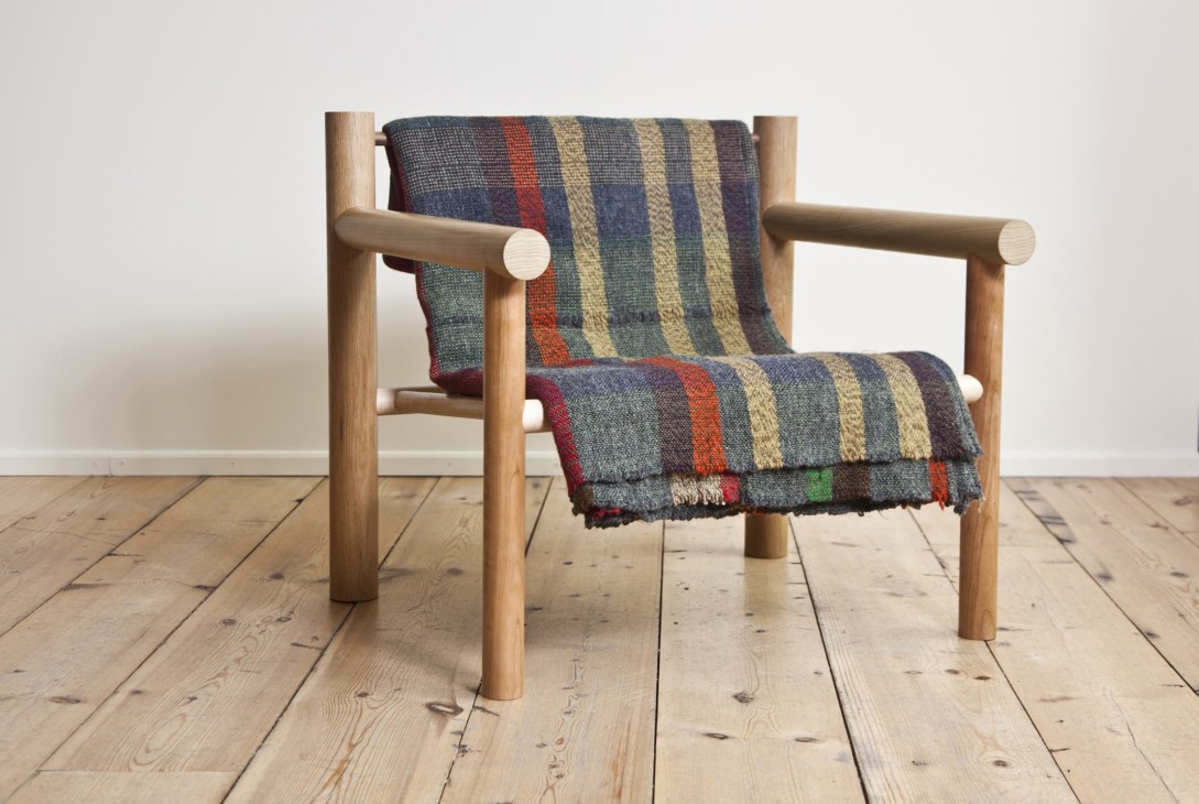 Wooden lounge chair with bent-steel frame and striped upholstered seat and backrest.