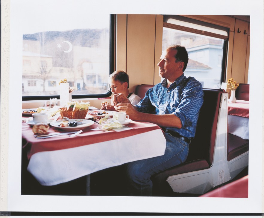 Australian Robert Reid and his young son Harry dining in the train's dining car with Lake Van visible through the windows.