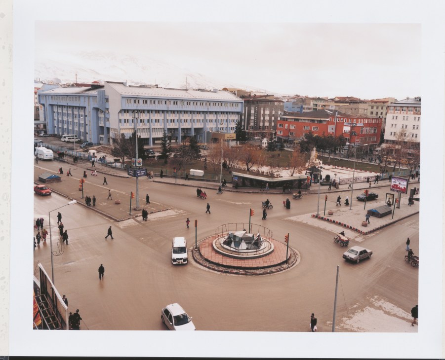 Aerial view of a public square in Van with buildings, vehicles, and pedestrians.