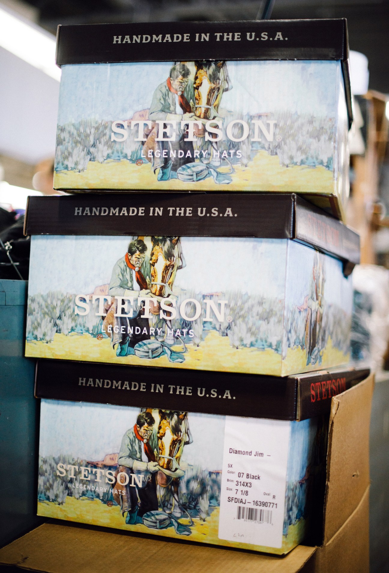 Stacked Stetson Legendary Hats boxes marked 'Handmade in the U.S.A.' with vintage Western imagery.