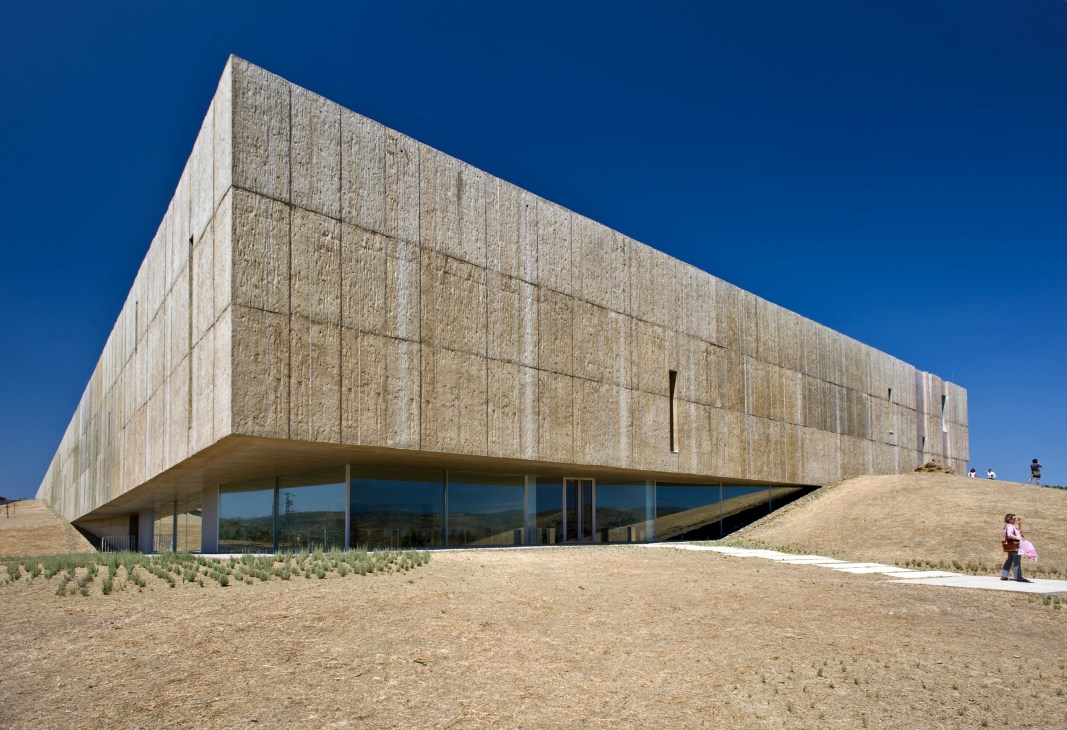 Modern stone museum building with vertical window slits on a hillside in Portugal's Côa Valley.