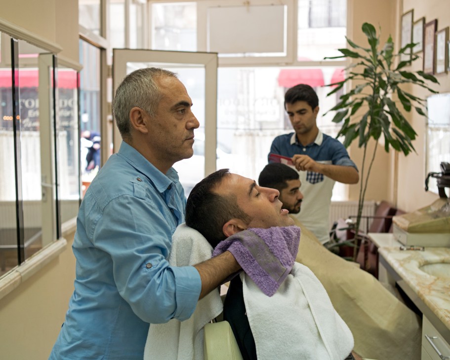 Master barber Huseyin Akbay applies a hot towel to finish a customer's shave at Cornedor barbershop in Istanbul.