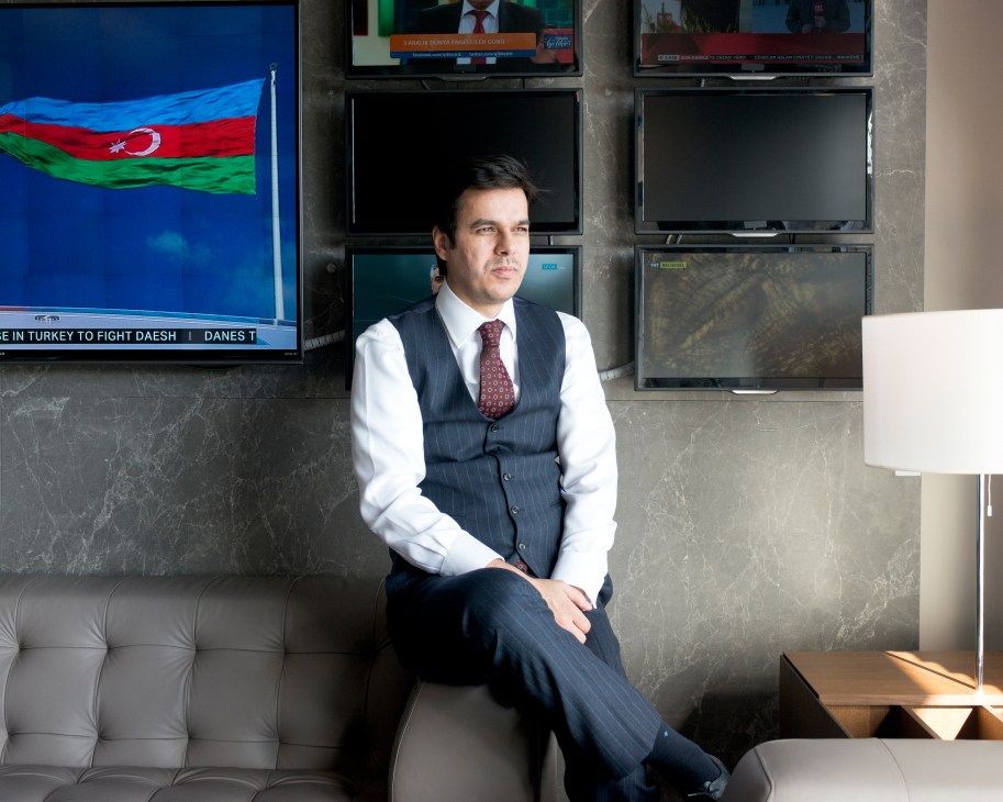 Ibrahim Eren sits in an office with television screens and Turkish flag visible behind him.