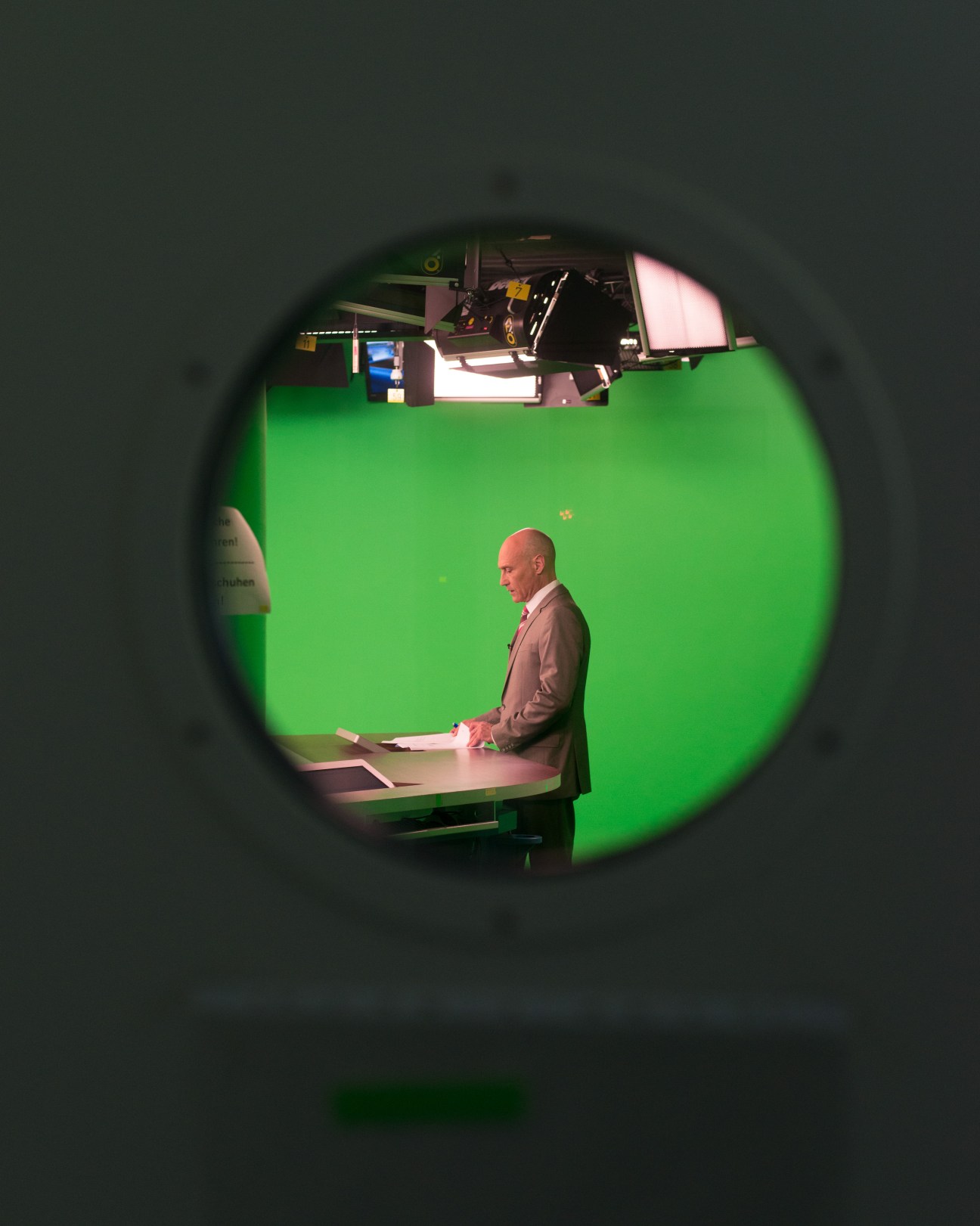 Martin Wirsing, anchor of 'Hessenschau Kompakt', sits at a desk in front of a green screen in the HR television studio.