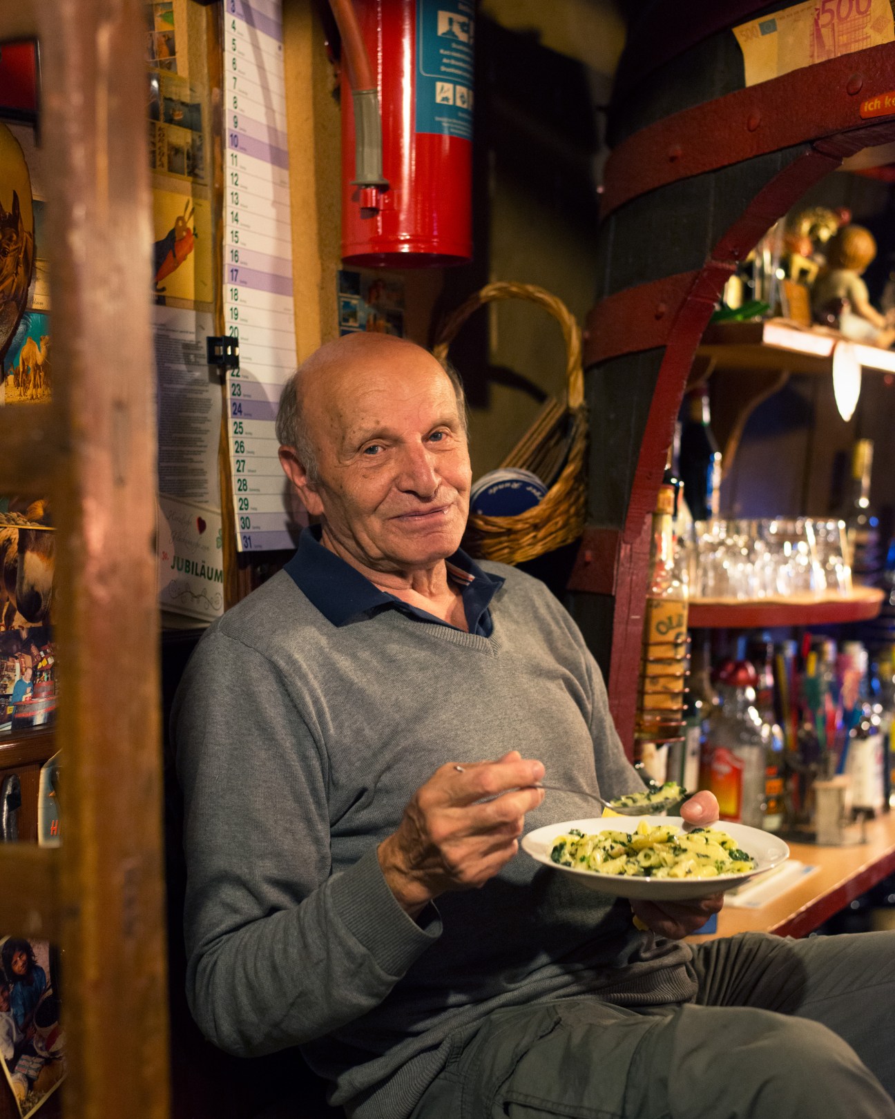 Gute Stute pub owner eating at the bar surrounded by vintage decorations