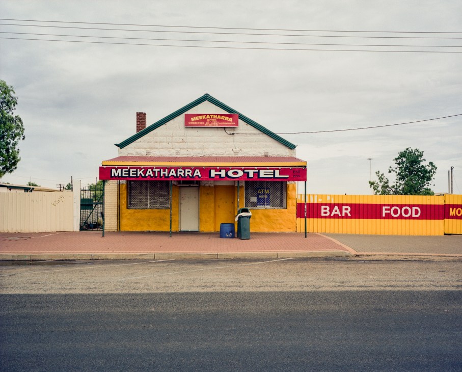 The Meekatharra Hotel with yellow facade and red signage for bar and food.