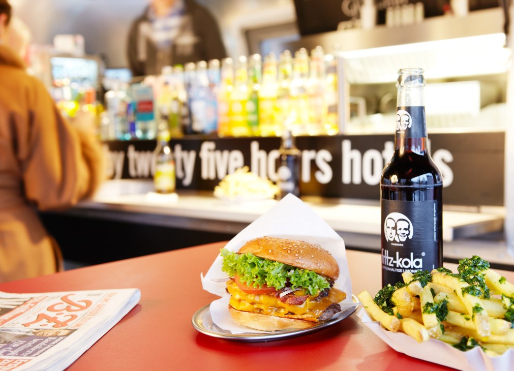 Burger de Ville mobile kitchen serves organic beef burger with lettuce, cheese and bacon on brioche bun, accompanied by parsley-garlic fries and local beer.