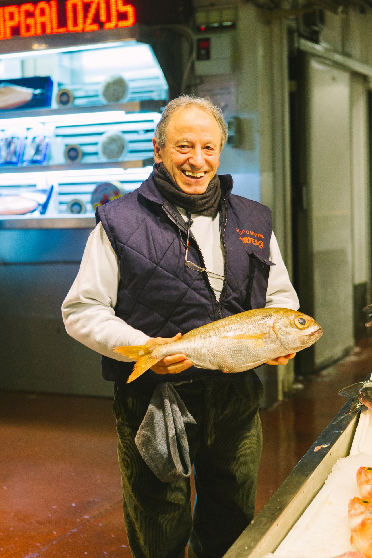 Ángel Mozos Ramírez holds a golden pandora fish at Serpeska stall in Mercamadrid market.