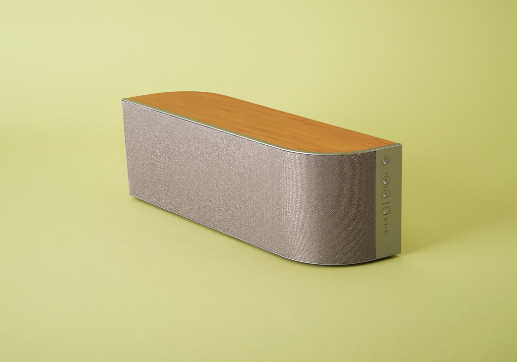 Wren V5BT speaker with natural bamboo top and fabric sides on yellow background.