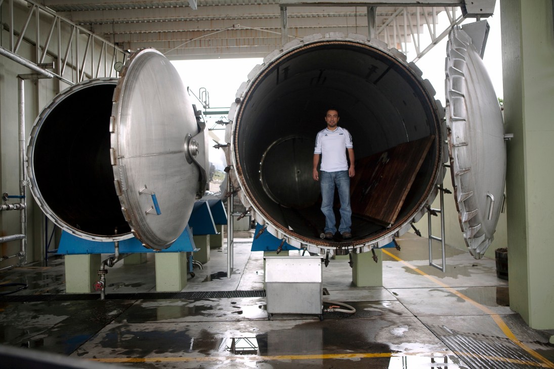 Quality-control engineer Emmanuel Bautista stands inside a large steam-powered industrial oven at Beneva mezcal facility.