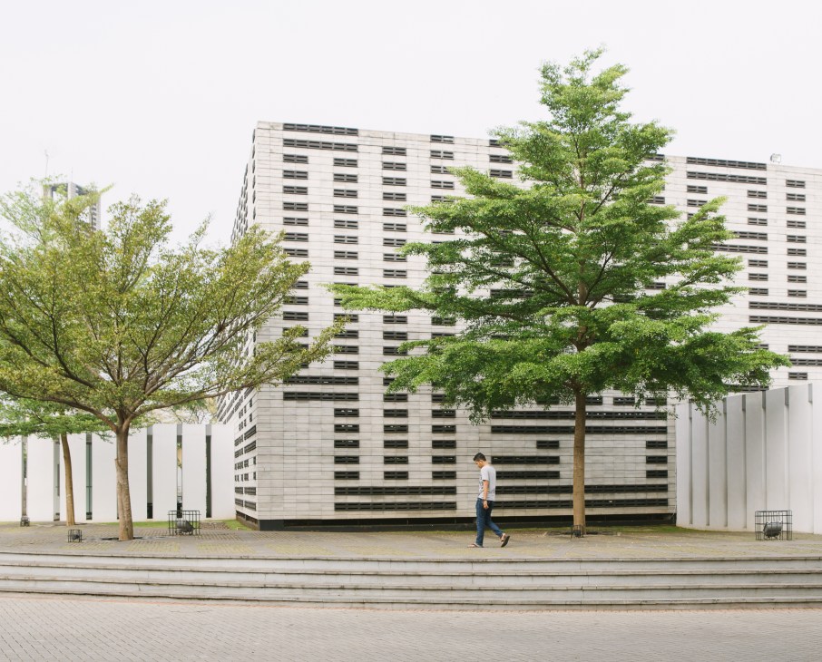 Al Irsyad Satya Mosque by architect Ridwan Kamil, featuring modern striped facade with green trees in front plaza.