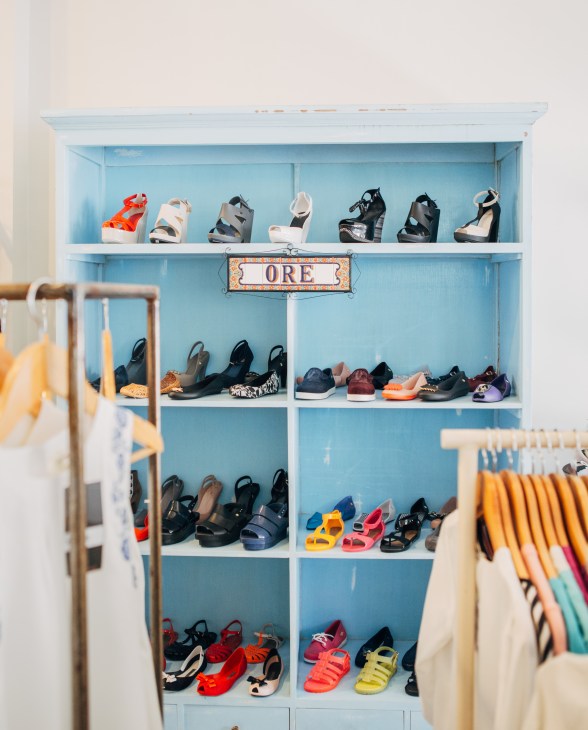 Blue shelving unit displaying colorful platform sandals and shoes with ORE signage